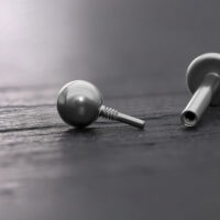 Titan-Kugel für Labrets in Silber, 3mm Silberne Titan-Kugel für Labrets auf dunklem Hintergrund