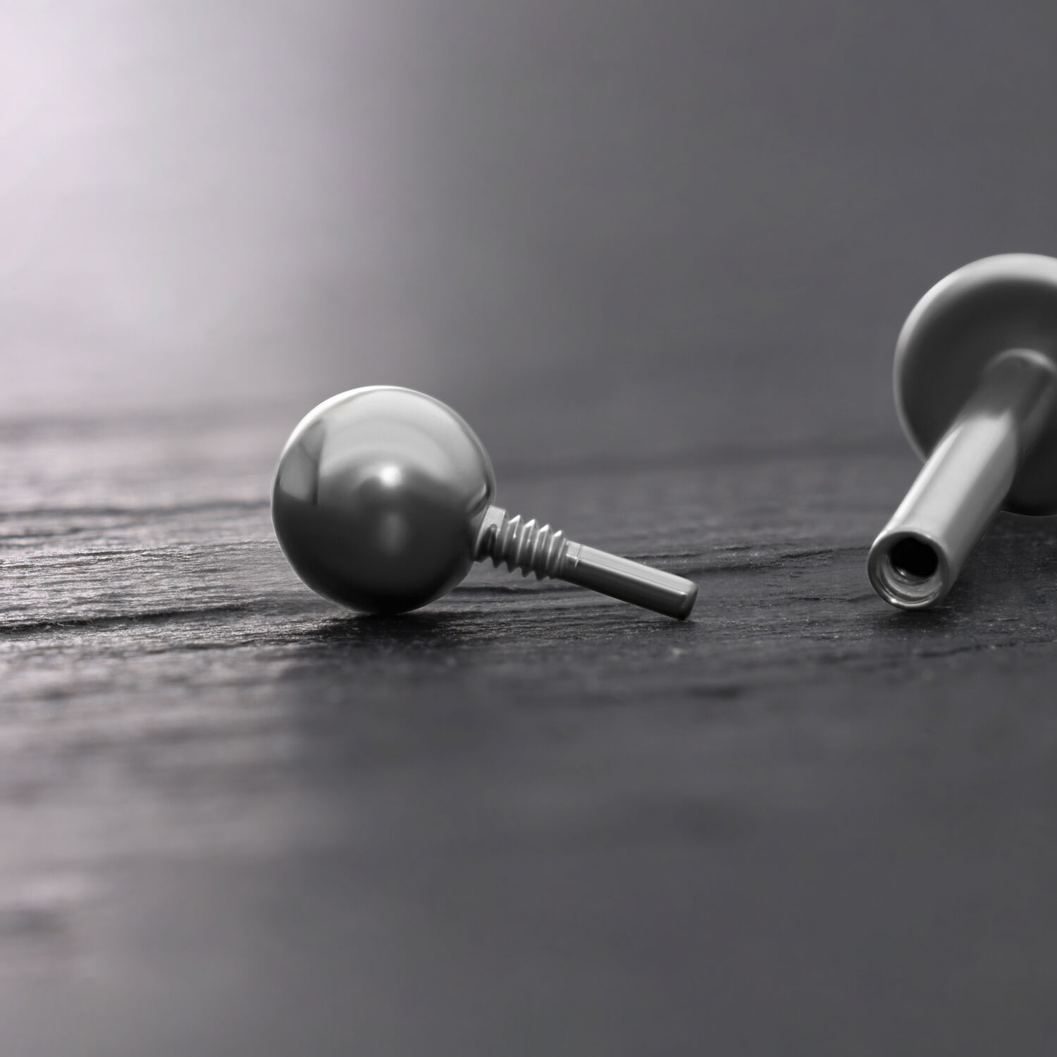 Titan-Kugel für Labrets in Silber, 3mm Silberne Titan-Kugel für Labrets auf dunklem Hintergrund