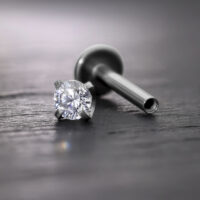 Prong Aufsatz für Innengewinde in Silber Silberner Prong Aufsatz mit Kristall für Innengewinde Labret auf grauem Hintergrund