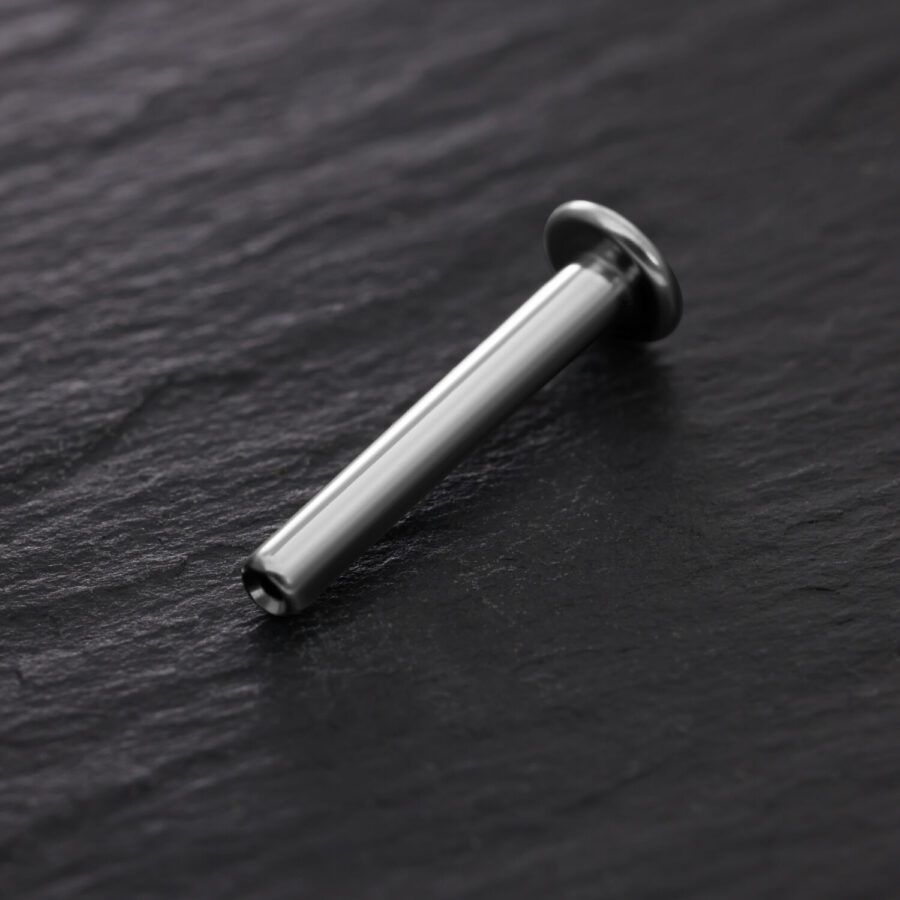 Silbernes Titan Labret Pushfit auf schwarzem Hintergrund