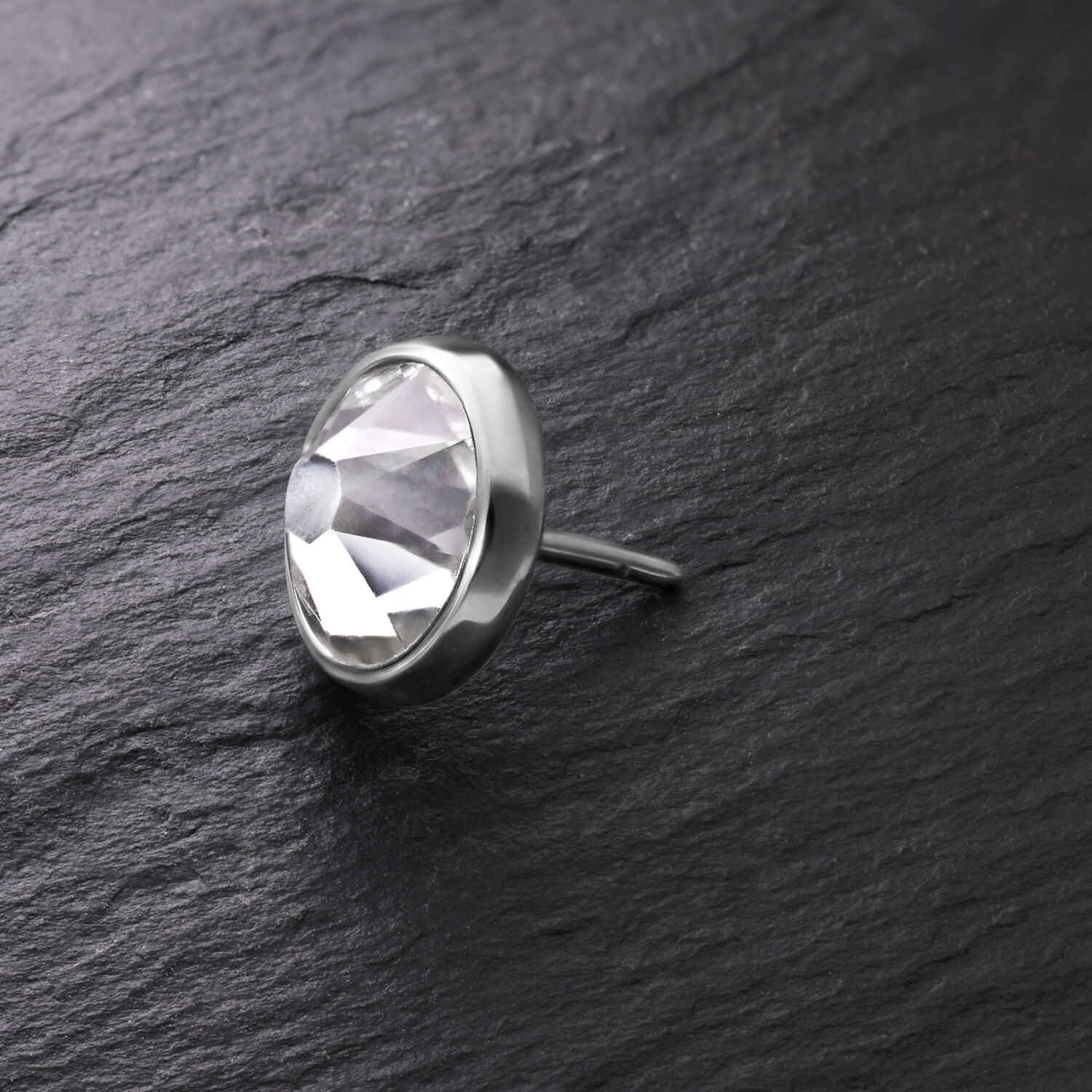 Silberne Disc für Triple Piercing mit klarem Kristall auf dunklem Hintergrund