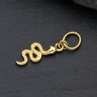 18K Gold Schlangen-Anhänger für Piercings Goldener Schlangen-Anhänger aus 18K Gold auf schwarzem Hintergrund
