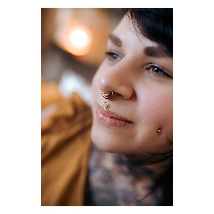 Oriental Sun Push-Fit Labret im Ohr getragen Nahaufnahme einer Person mit Oriental Sun Push-Fit Labret im Nasenpiercing, goldene Farbe