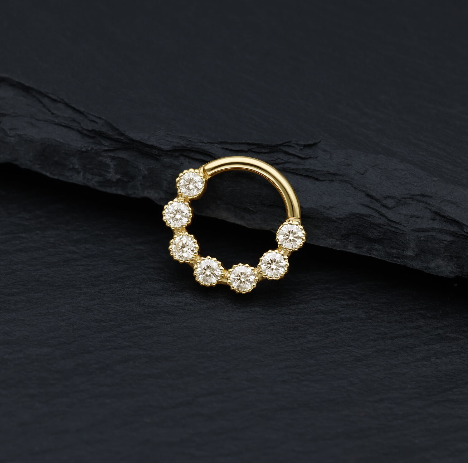 18K Gold Septum Ring mit Moissanit Steinen Goldener Piercingring mit funkelnden Moissanit Steinen auf schwarzem Hintergrund