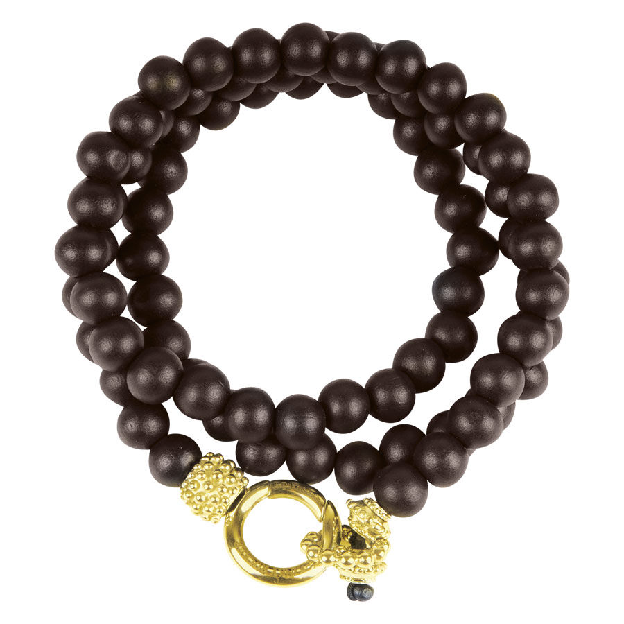 Goldenes Armband aus Ebenholzperlen Doppeltes Armband aus dunklen Holzperlen mit goldener Verschluss auf weißem Hintergrund