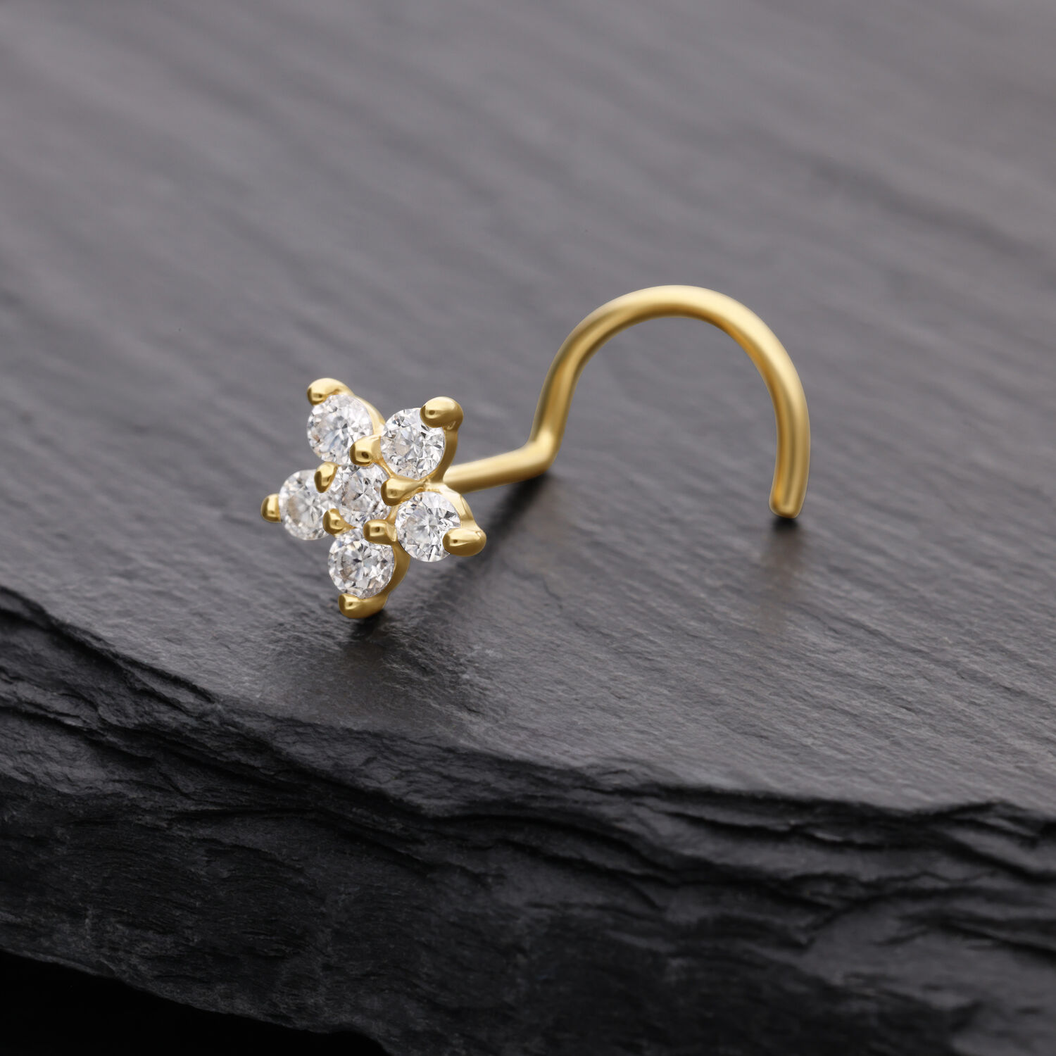 Goldener Nasenstecker mit blumenförmigem Moissanit-Kristall auf dunklem Hintergrund
