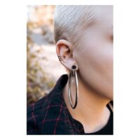 Schwarze Hollowed Hoops am Ohr getragen Nahaufnahme eines Ohrs mit großen, schwarzen Hollowed Hoops von Wildcat