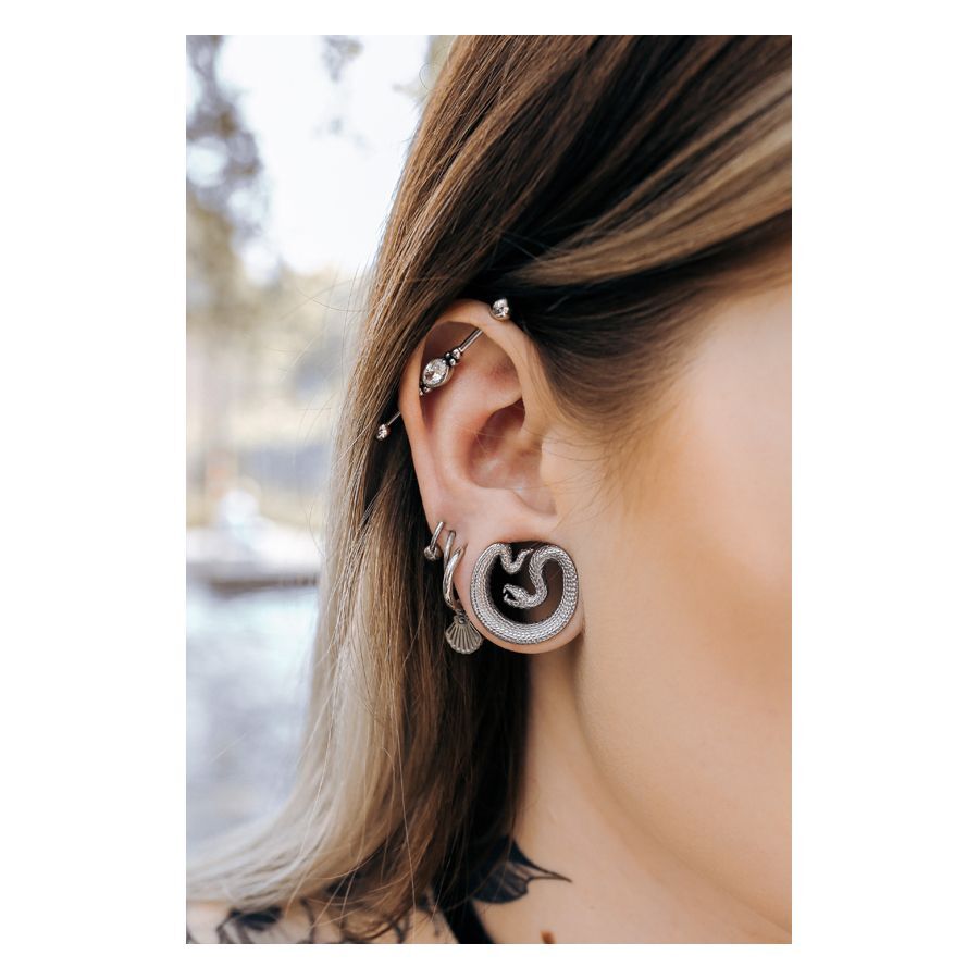 Schwarze Ear Saddles Snake im Ohr Schwarze Ear Saddles in Schlangenform im Ohr getragen, Piercing im Freien