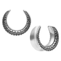 Maori Ear Saddles aus Chirurgenstahl Zwei silberne Ear Saddles mit Maori-Muster auf weißem Hintergrund