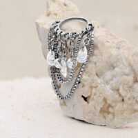 Silberner Kristall Snakechain Clicker Silberner Clicker mit kristallklaren Kristallen auf hellem Stein