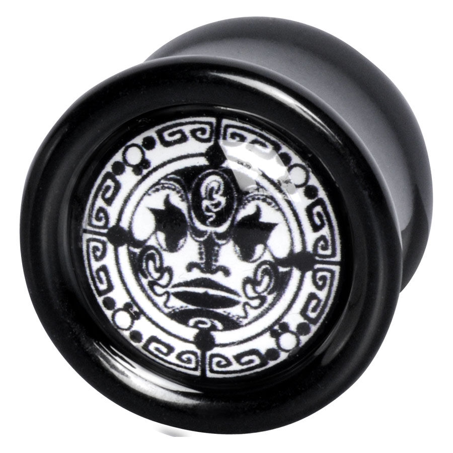 Runder schwarzer Plug aus PMMA mit Maori-Mondmotiv auf weißem Hintergrund