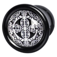 Schwarzer PMMA Plug mit weißem Maori-Muster auf Studiohintergrund
