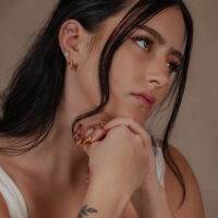 14K Gold Moissanit Blumenaufsatz für Piercings Frau mit 14K Gold Moissanit Blumenaufsatz am Ohr, dezenter Hintergrund