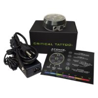 Critical Atomx Netzteil in Schwarz mit Zubehör Schwarzes Critical Atomx Netzteil mit Kabel und Bedienungsanleitung auf weißem Hintergrund