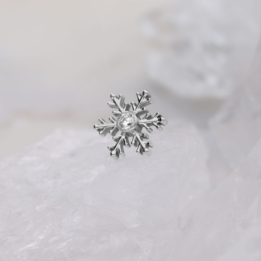 Silberner Schneeflocken-Piercingaufsatz mit klarem Kristall auf weißem Hintergrund