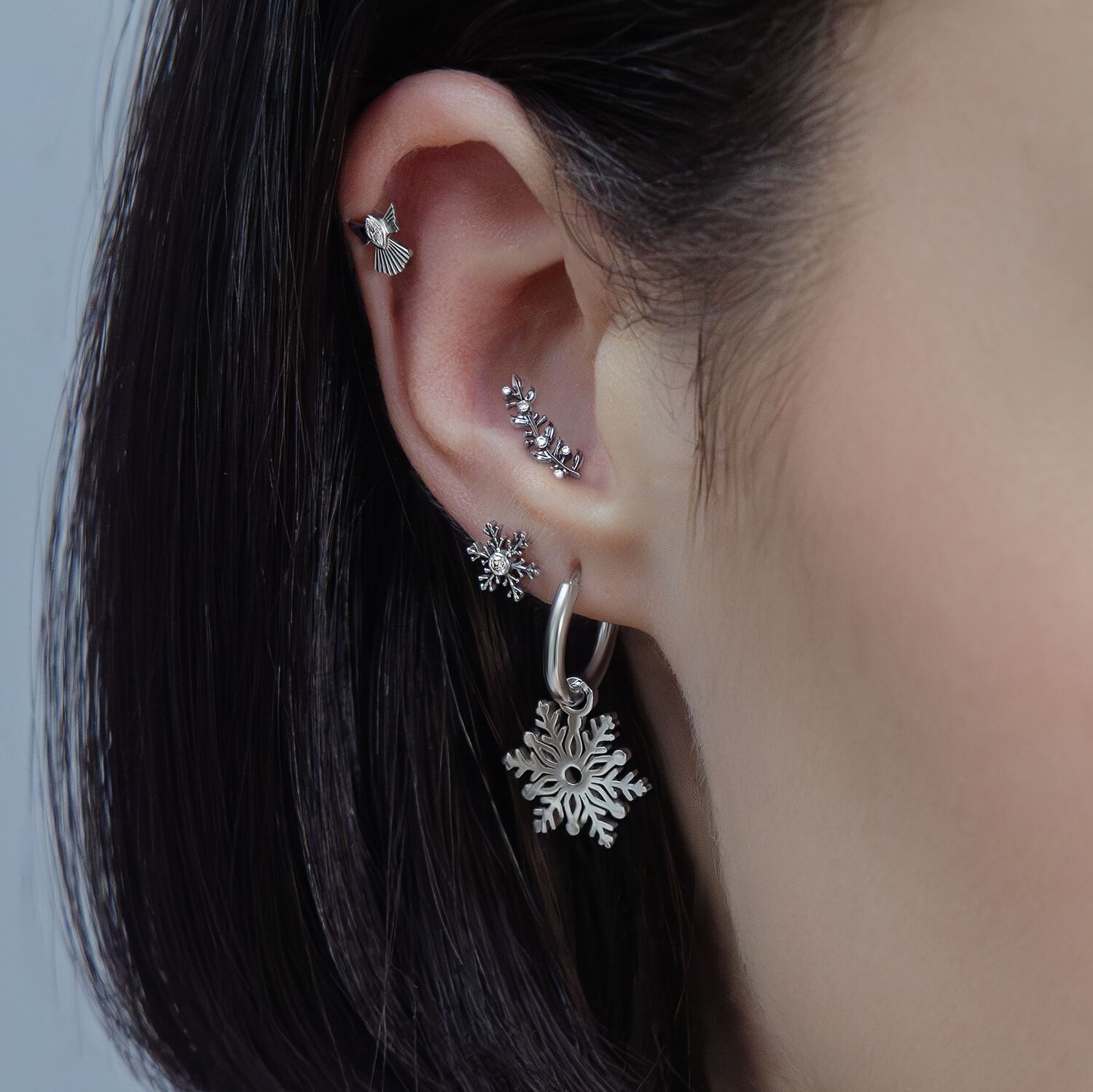 Silberne Push Fit Piercing Aufsätze mit Kristall Nahaufnahme eines Ohrs mit mehreren silbernen Piercings in verschiedenen Designs und Kristallen