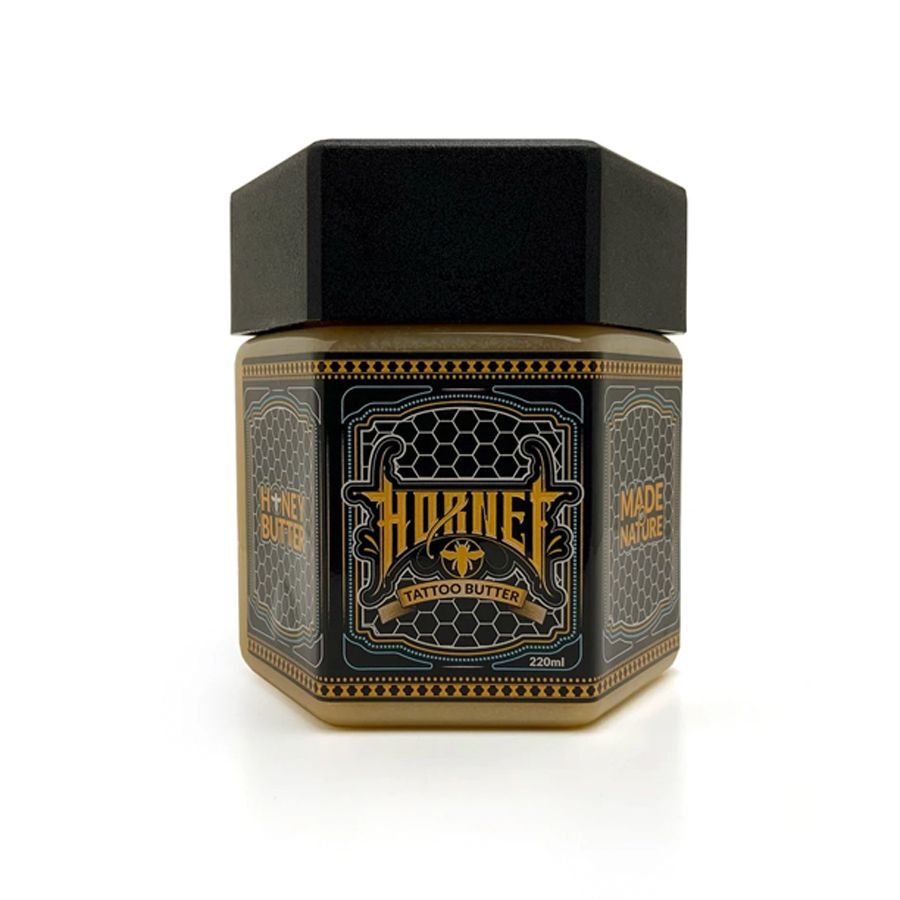 Schwarzes und goldenes Hornet Honey Butter Glas auf weißem Hintergrund