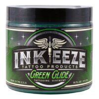 Grüne Tattoocreme in runder Dose mit silbernem Logo auf weißem Hintergrund