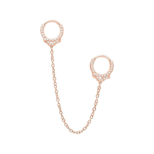 Roségoldene Piercingringe mit Glitzersteinen und Kette auf weißem Hintergrund