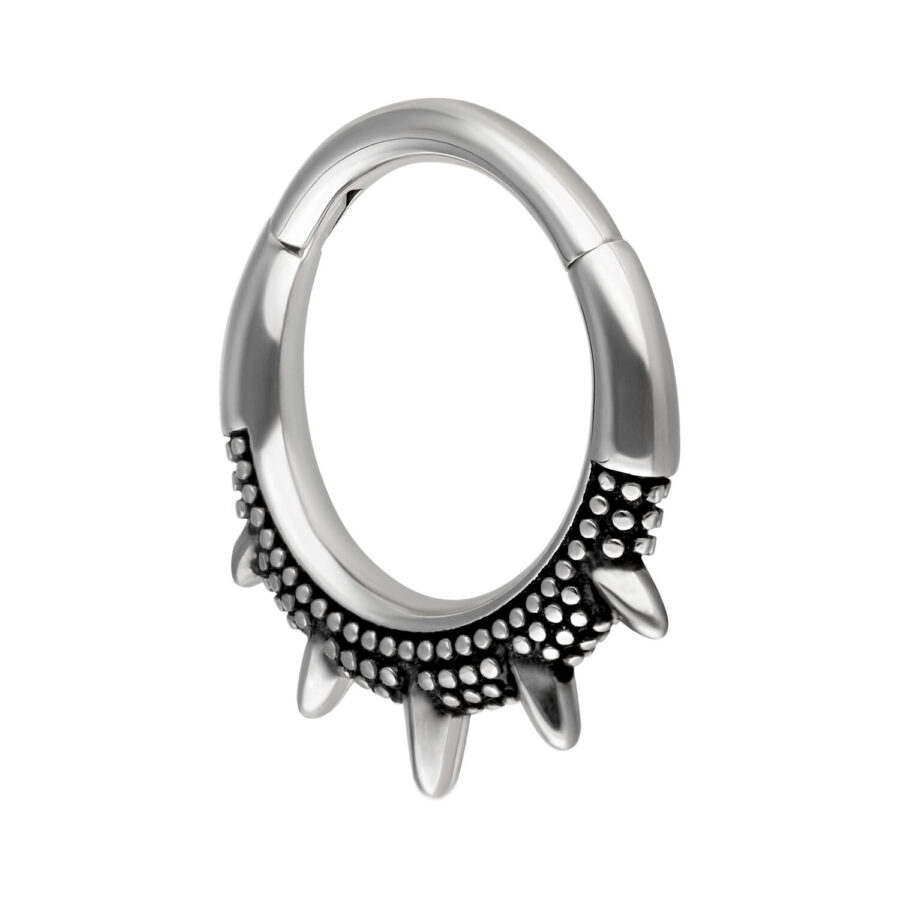 Silberner und schwarzer Piercingring mit stachelartigem Design auf weißem Hintergrund