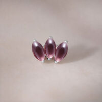 Silberner Lotus-Aufsatz mit Amethyst Silberner Lotus-Aufsatz mit drei Amethyststeinen auf neutralem Hintergrund