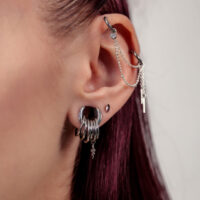 Silberne Push Fit Aufsätze mit Amethyst Nahaufnahme eines Ohres mit silbernen Piercingaufsätzen und Ketten