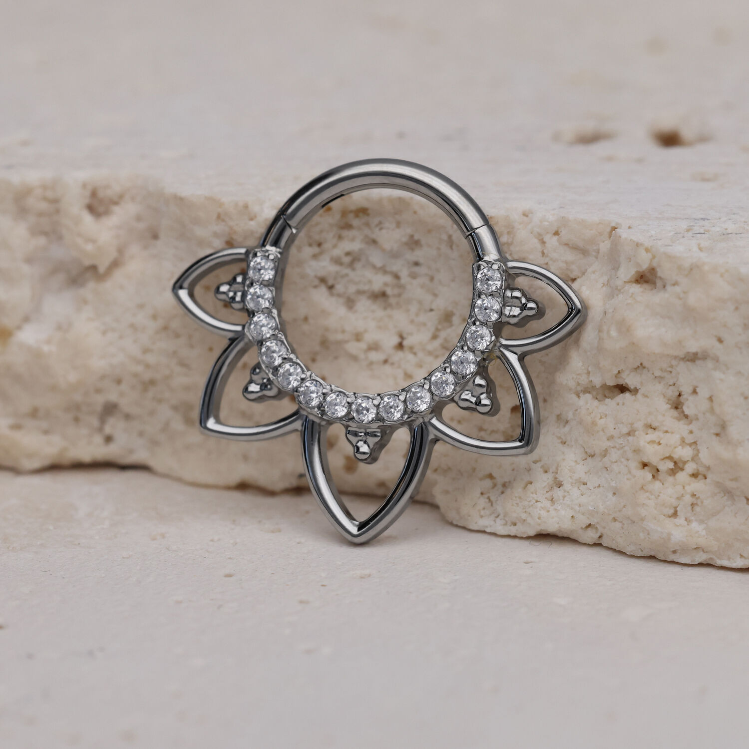 Titan Septum Clicker mit Kristallen Silberner Septum Clicker mit klaren Kristallen auf hellem Stein