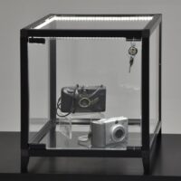 Schwarzer Glas-Vitrinen-Würfel mit LED-Streifen, zwei Kameras innen