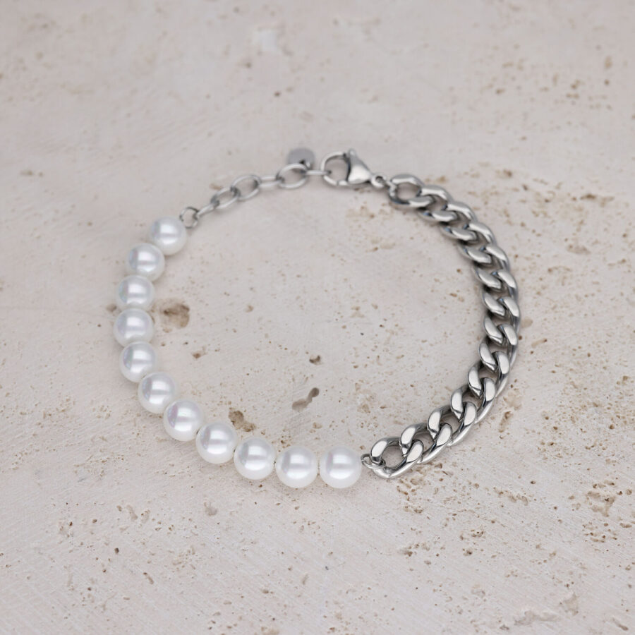 Armband mit weißen Perlen und silberner Kette auf hellem Stein