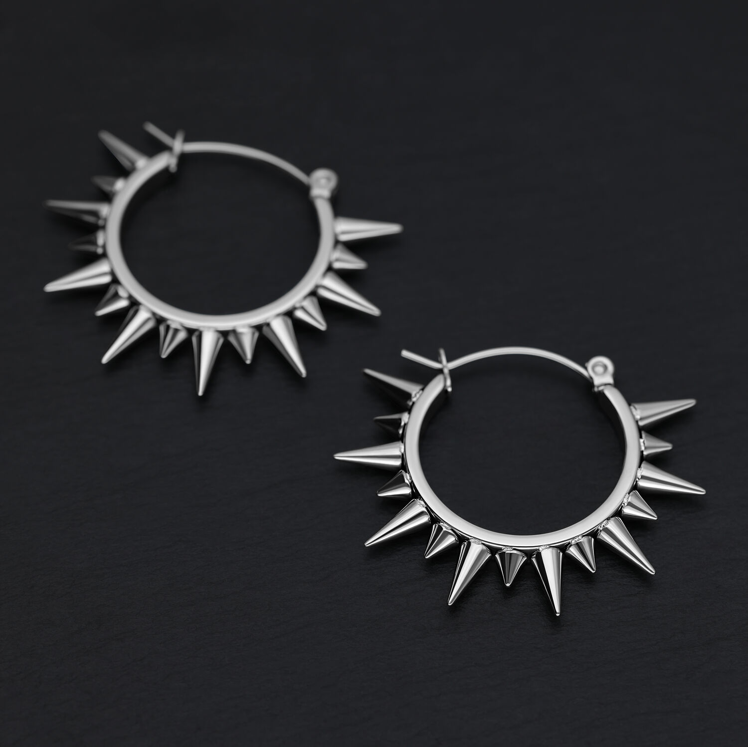 Silberne Spiked Ohrringe aus Stahl Zwei silberne Spiked Ohrringe aus Chirurgenstahl auf schwarzem Hintergrund