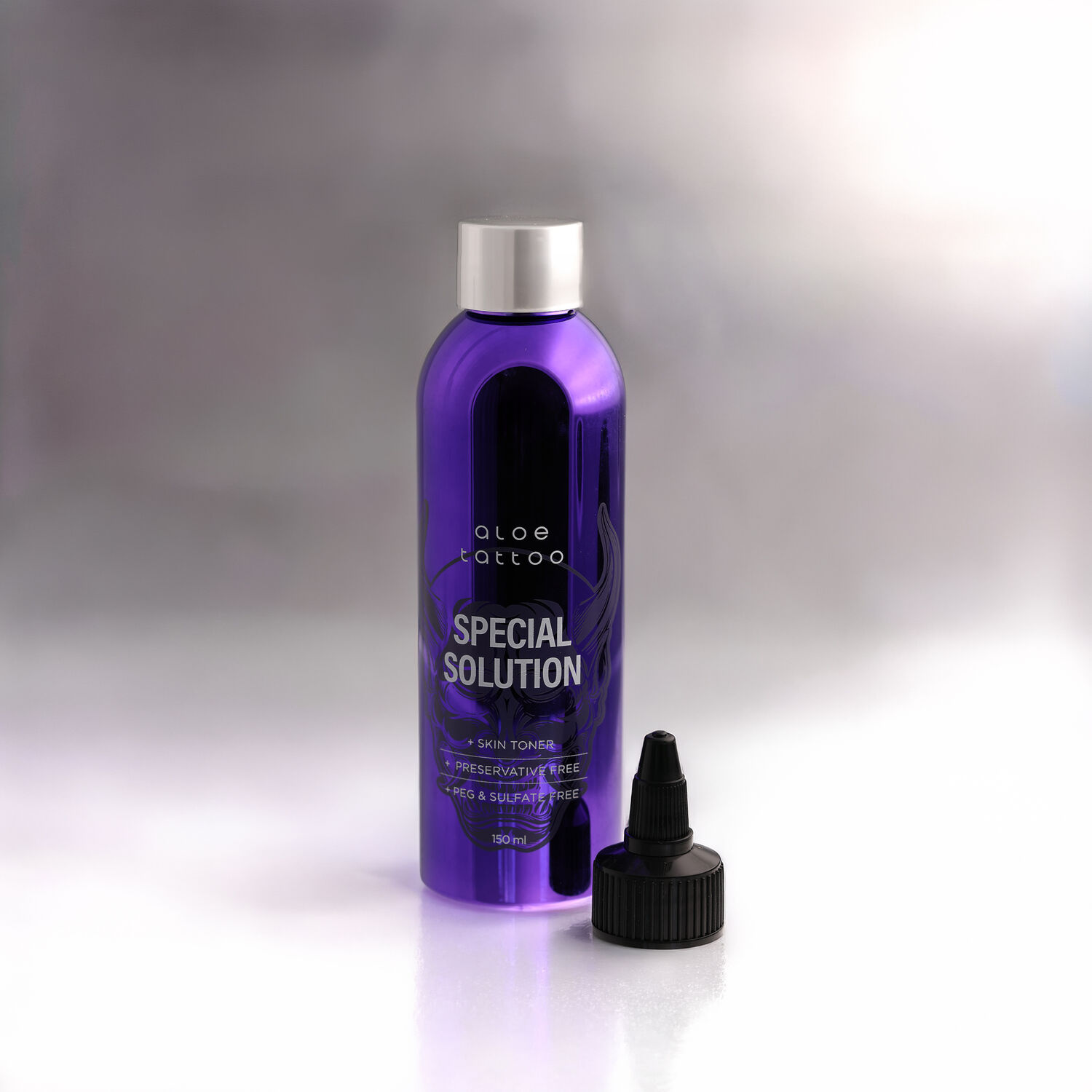 Lila Flasche Aloe Tattoo Special Solution mit schwarzem Deckel auf weißem Hintergrund