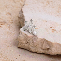 Silbernes Blumen-Piercing auf hellem Stein mit Zirkonia-Dekoration