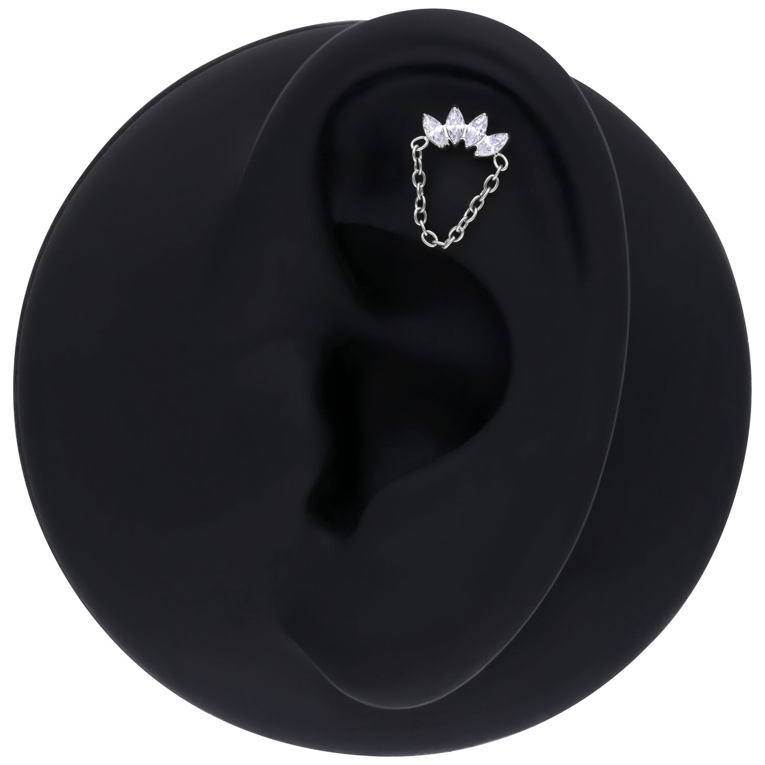Ohrpiercing aus Silber mit Kette und drei Kristallen auf schwarzem Hintergrund