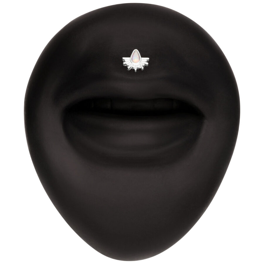 Schwarzer Hintergrund mit einem kleinen, weißen Aufsatz in Form von Sonnenstrahlen, verziert mit einem opalisierenden Stein.
