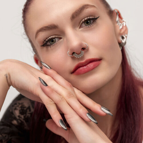 Frau mit rotem Haar trägt einen silbernen Septum Clicker mit Kugelverzierung