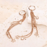Roségoldene Creolen mit langen Ketten und Blumenanhängern auf hellem Stein