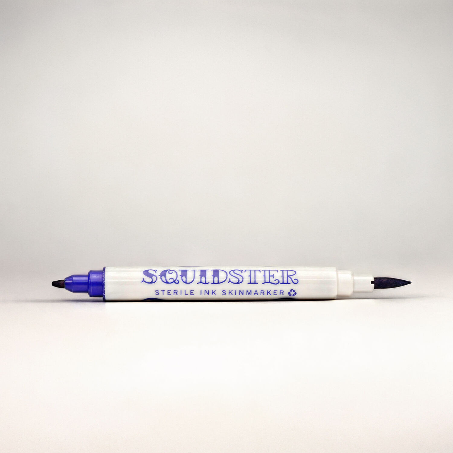 Blauer Tattoo Marker mit Doppelspitze Weißer Marker mit blauer Kappe und Spitze auf neutralem Hintergrund