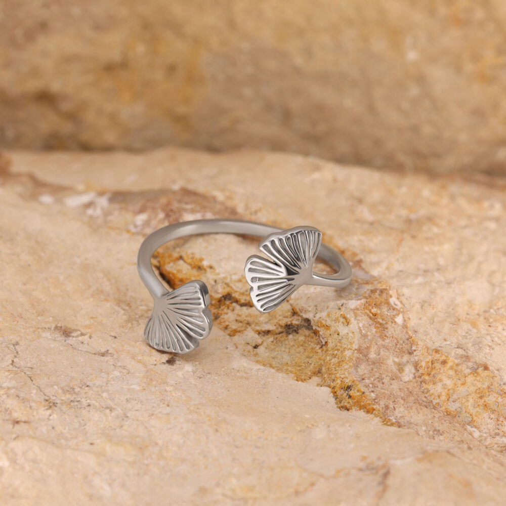 Zweiteiliger silberner Ring mit Ginkgo-Blatt-Motiven auf beigem Stein