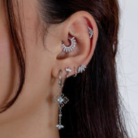 Ohren mit silbernen Tiara-Piercings, verschiedene Designs, auf weißem Hintergrund