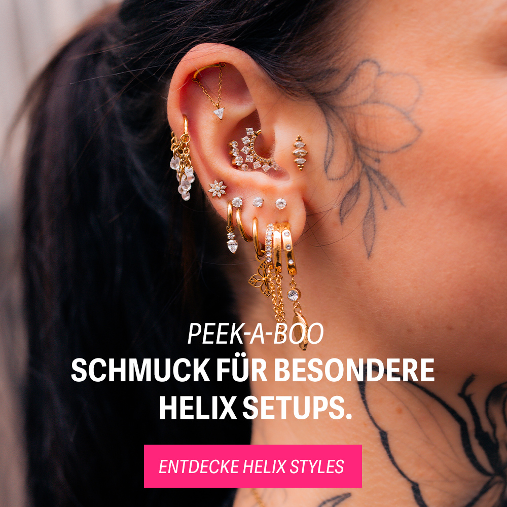 Nahaufnahme eines Ohres mit mehreren goldenen Helix-Piercings, Blumen-Tattoo im Hintergrund