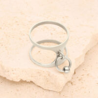 Silberner Ring mit Piercing-Design auf hellem Stein platziert