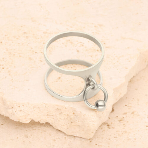Silberner Ring mit Piercing-Design auf hellem Stein platziert