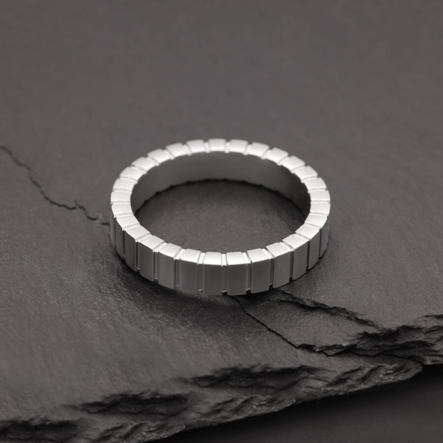 Silberner Ring aus Chirurgenstahl auf grauem Steinuntergrund