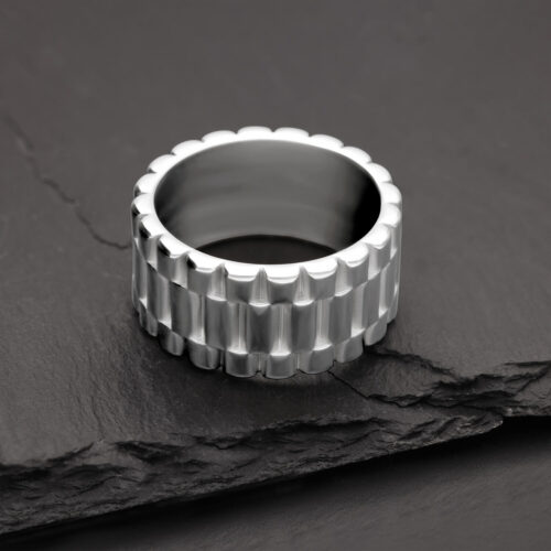 Silberner Ring mit geriffeltem Design auf schwarzem Schiefer