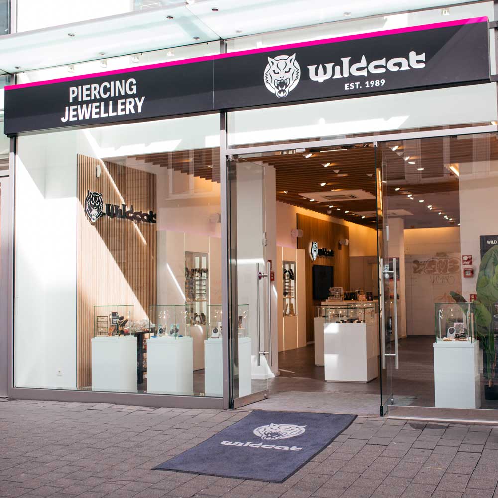 Eingang des Wildcat Piercing Schmuckgeschäfts mit Glastüren und Logo