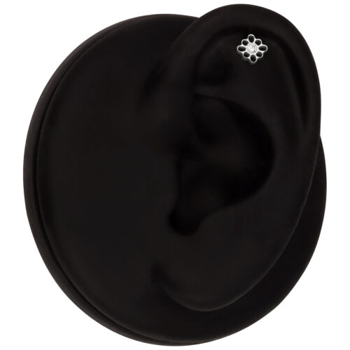 Schwarzes Ohrmodell mit weißgoldenem Blumen-Piercing im Helix-Bereich