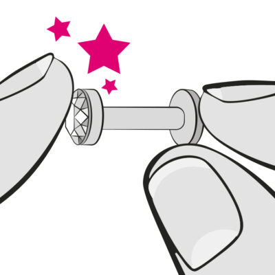 Nahaufnahme eines Push-fit Steckers mit Glitzerstein, gehalten von zwei Händen auf weißem Hintergrund